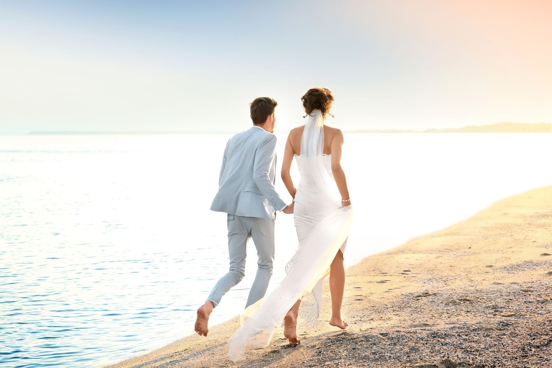 A wedded couple running in the beach near Titanic Mardan Palace