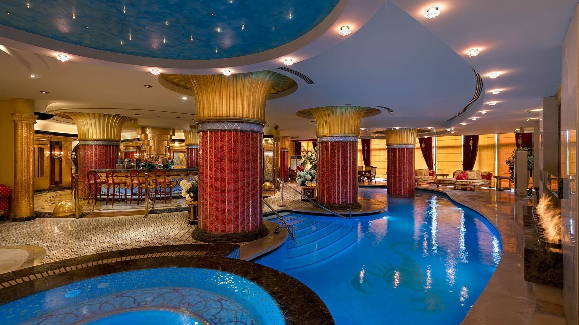 An indoor swimming pool by the hotel lobby at Titanic Mardan Palace