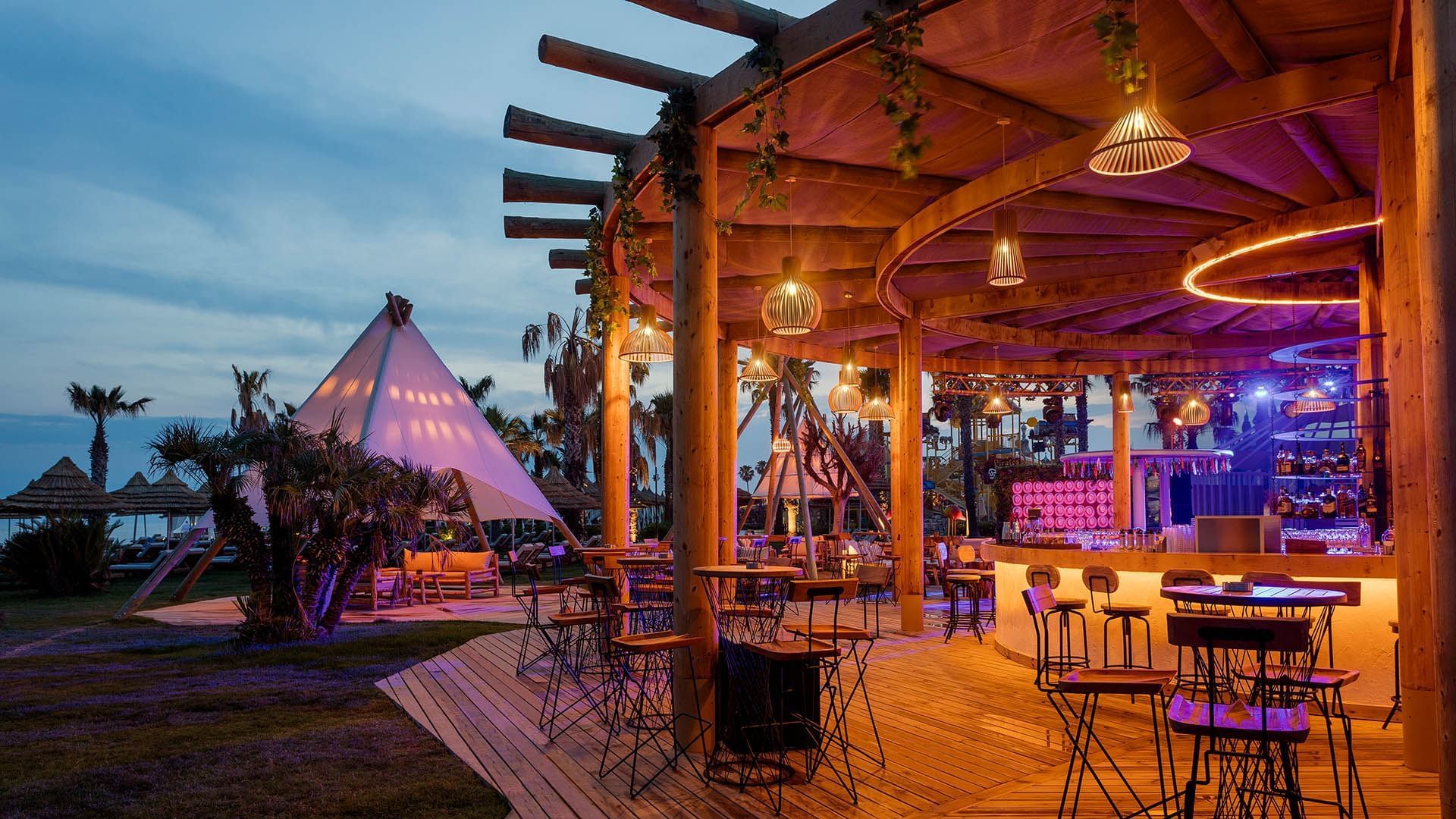 Outdoor beach bar with wooden floor and the sitting area at Titanic Mardan Palace